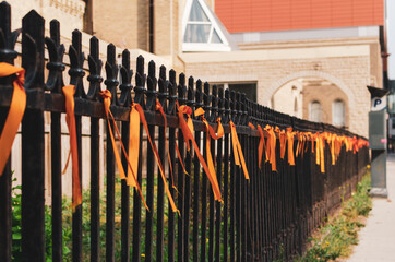 orange ribbons tied to a wrought iron fence outside Saint Mary's Cathedral, Winnipeg, Manitoba,...