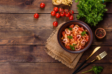 Fototapeta na wymiar Fettuccine pasta with shrimp, cherry tomatoes, sauce, spices and herbs