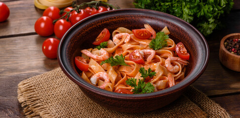 Fettuccine pasta with shrimp, cherry tomatoes, sauce, spices and herbs