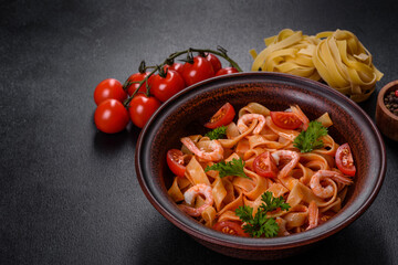 Fettuccine pasta with shrimp, cherry tomatoes, sauce, spices and herbs