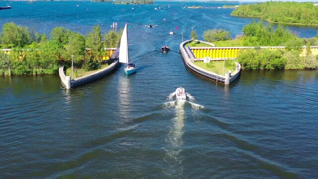 Aquaduct Veluwemeer, Nederland. Aerial view from the drone. A sailboat sails through the aqueduct on the lake above the highway. High quality 4k footage