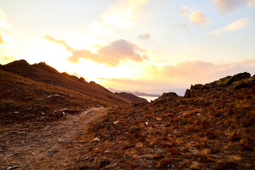 Nature landscape with golden hills, sun, blue sky with yellow clouds in a day or a evening during sunset