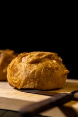 latin american stuffed potato, bolon. vertical photo with cutlery on wooden board.