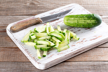 Cucumber slices on a cutting board for making green beans salad. Step by step recipe.