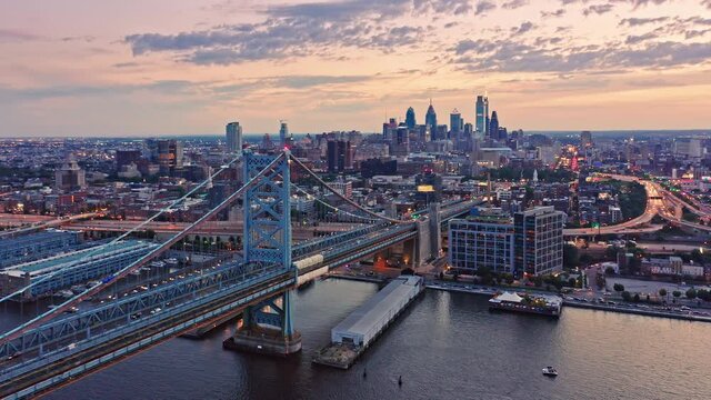 Aerial view Ben Franklin Bridge and Philadelphia skyline with slow camera motion towards ther city, at dusk. Benjamin Franklin Bridge is a suspension bridge connecting Philadelphia and Camden, NJ.
