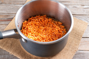 Red lentils in a saucepan for making lentil soup. Step by step.