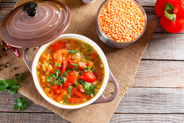 Red soup with lentils and vegetables on a table. Healthy food, healthy food. Top view with copy space