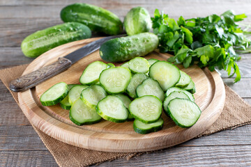 Fresh sliced green cucumbers on a cutting board on a table. Healthy vegetarian ingredient