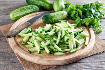 Fresh sliced green cucumbers on a cutting board on a table. Healthy vegetarian ingredient