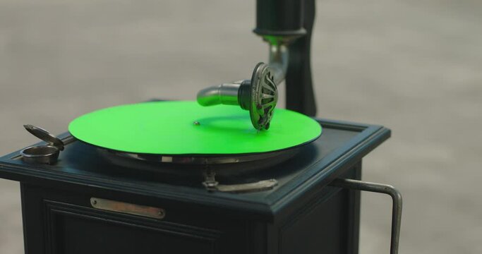 Vintage gramophone . Vintage old gramophone plays a vinyl record on green screen background . Wooden case turntable . Vinyl phonograph . Shot on ARRI ALEXA Cinema Camera in slow motion .