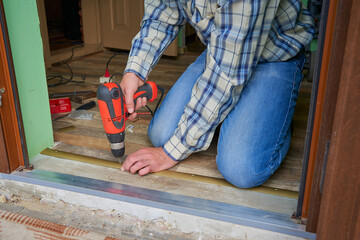 man is making a threshold on the floor,Installation of self-adhesive threshold when docking floor...