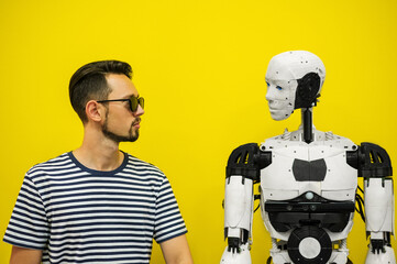 man communicates with a robot on a yellow background. man negotiates with artificial intelligence