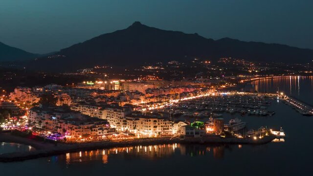 Aerial drone time-lapse of Puerto Banus Marbella marina luxury port in Spain hyper lapse from dusk to night