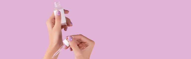 Womans hand holding dropper with serum on pastel lavender background