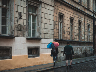 people walking along the old streets of the city, woman with colorful umbrella