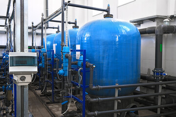 blue water tanks inside wastewater treatment facility with sensors, industrial interior