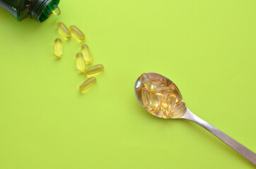 omega 3 dietary supplement is poured out of the package into a spoon