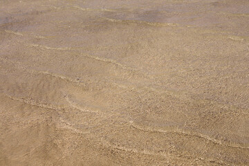 Clear waves and colorful sand on tropical sandy beach in Crete Greece.