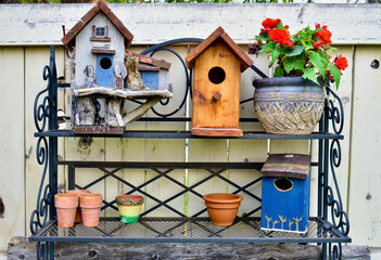 Backyard artistic arrangement of wooden painted birdhouses on garden potting bench, outdoor lifestyle gardening with rustic decor