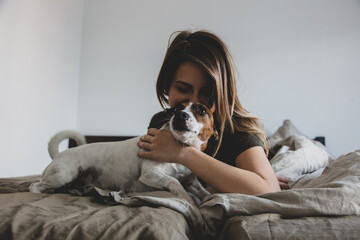 Woman with dog in a bed