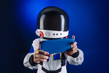 Teenager wearing astronaut costume and helmet using smartphone