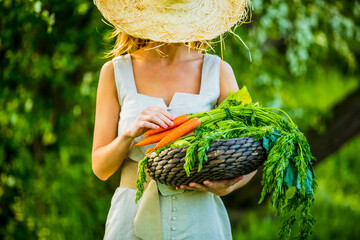 young woman with vegetable basket in a garden