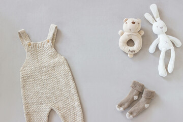 flat lay baby clothes and toys on gray background 