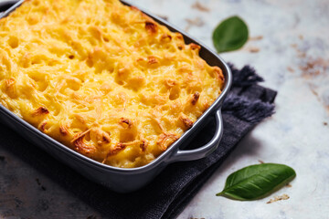 Mac and cheese baked in oven with basil leaves