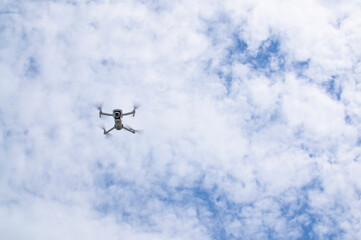 Flying quadcopter or drone high in the sky.