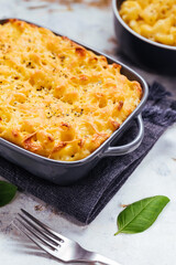 Mac and cheese baked in oven with basil leaves
