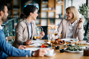 Group of happy entrepreneurs talk while enjoying in business lunch in restaurant.