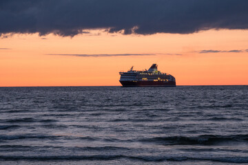 Cruise ship sailing at the horizon on the Baltic Sea after sunset, beautiful dramatic colors