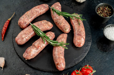  raw sausages for grilling on a stone background