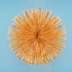 Dry straw wreath on a blue background. A decorative element for decorating your home with your own hands.