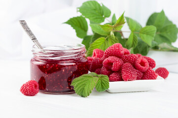 Jar of raspberry jam and fresh berries.