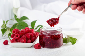 Jar of raspberry jam and fresh berries.