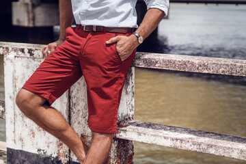 Moda męska, krótkie spodnie czerwone, bordowe, zdjęcie baner na reklamę. - obrazy, fototapety, plakaty