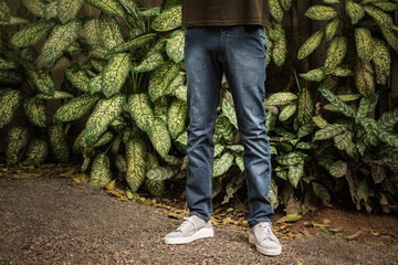 Męskie spodnie jeans niebieskie na modelu na naturalnym tle, zdjęcie reklamowe na baner.