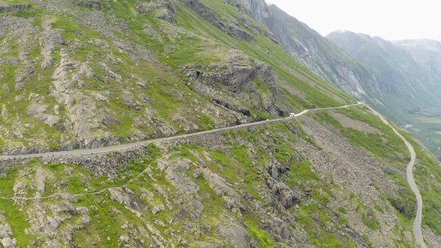 Distant View Of A White Vehicle Traveling On The Trollstigen Mountain Pass In More Og Romsdal, Norway. aerial