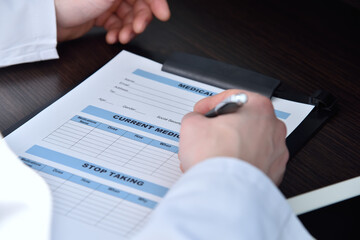 Doctor writing on clipboard