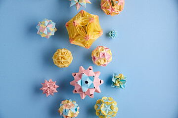 Set of multicolor handmade modular origami balls or Kusudama Isolated on blue background. Visual...