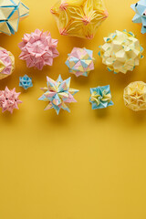 Set of multicolor handmade modular origami balls or Kusudama Isolated on yellow background. Visual...