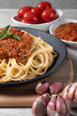 Traditional spaghetti a la putanesca on black plate.