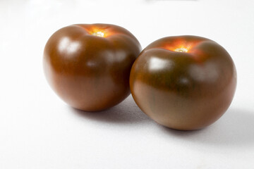 Brown tomatoes on white background.