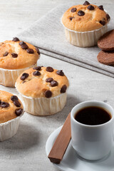 Muffin with drop of chocolate served with coffee and chocolate.