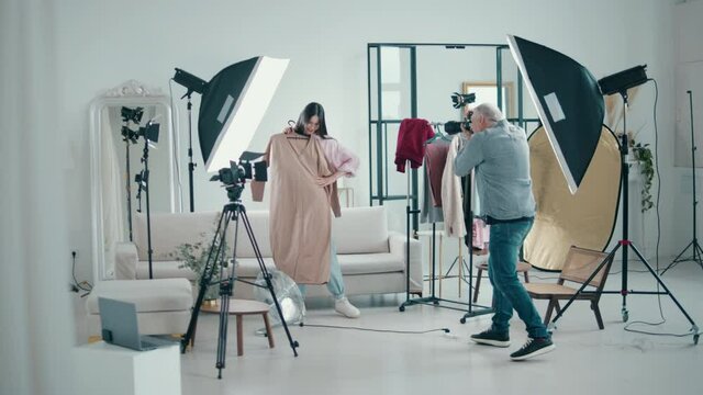 Lady model is being photographed with clothes in a studio