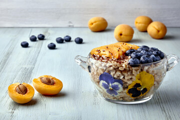 Whole grain oat flakes with blueberries, apricot slices, flax seeds and flowers