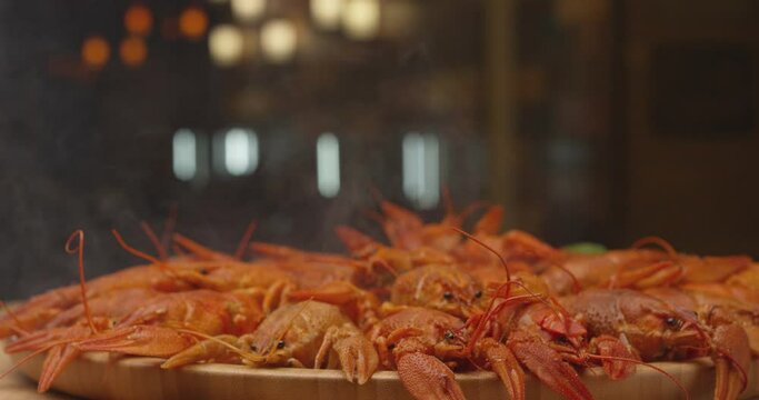 River boiled crayfish a good snack to beer. Waiter puts on the table a plate of boiled red river cancer . A plate of  fuming or smoking hot crawfish in the restaurant. Shot on RED Camera Slow motion. 