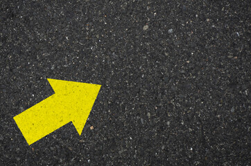 Asphalt with a yellow arrow sign pointing to the upper right. Tarmac road with an arrow pointing to...