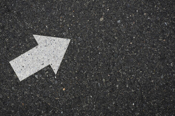 Asphalt with an arrow sign pointing to the upper right. Tarmac road with an arrow pointing to the upper right.